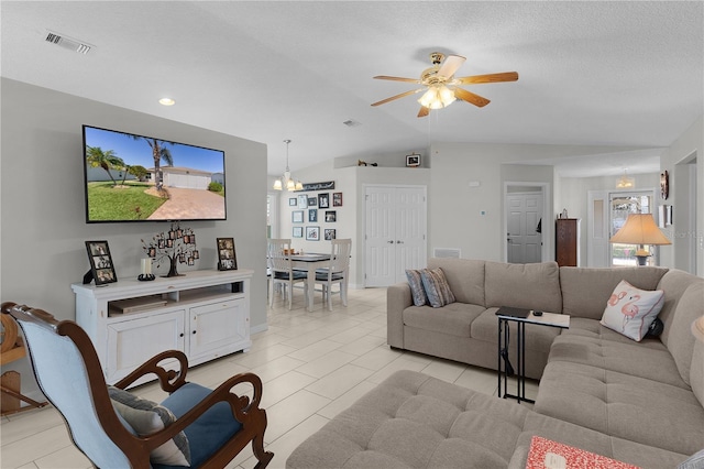 living room featuring visible vents, a textured ceiling, a ceiling fan, and lofted ceiling