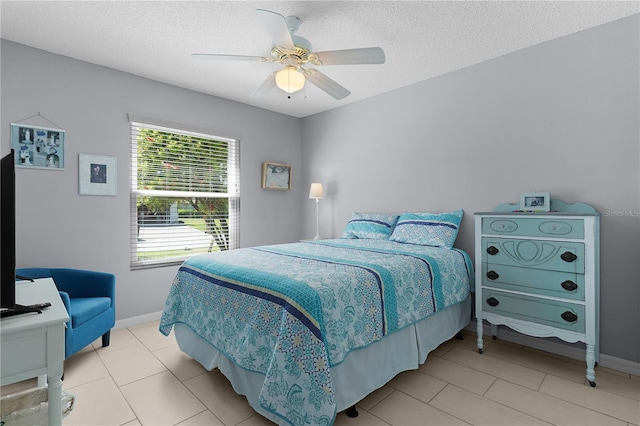 bedroom with light tile patterned floors, baseboards, a textured ceiling, and ceiling fan