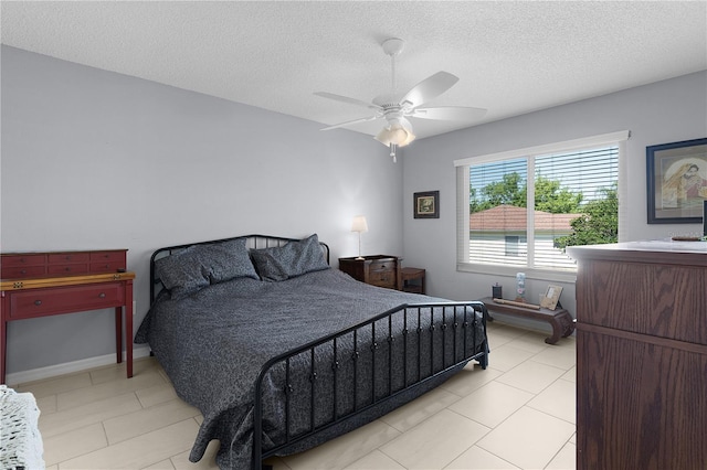 bedroom featuring light tile patterned floors, a textured ceiling, and a ceiling fan