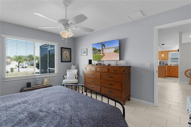 bedroom with baseboards, a textured ceiling, and ceiling fan