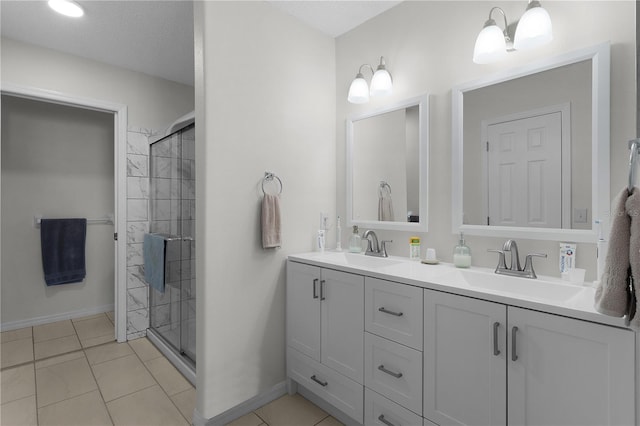 full bath with a sink, a shower stall, and tile patterned floors