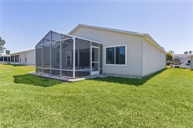 back of property with a lawn and a lanai