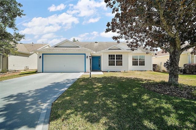 ranch-style home featuring a front lawn, an attached garage, and driveway