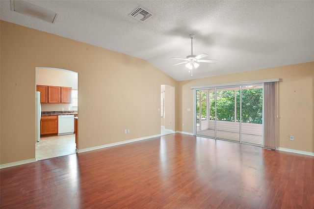 unfurnished room featuring visible vents, lofted ceiling, ceiling fan, a textured ceiling, and light wood-type flooring