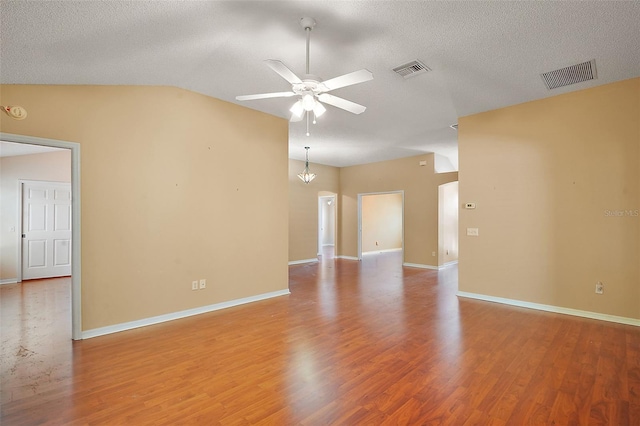 unfurnished room with a ceiling fan, wood finished floors, and visible vents