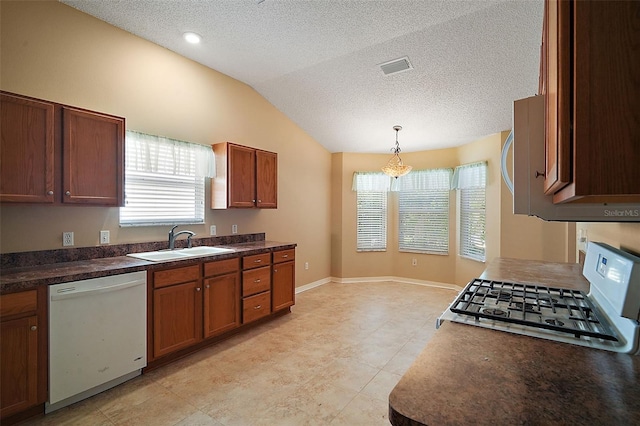 kitchen featuring visible vents, lofted ceiling, range with gas stovetop, white dishwasher, and a sink