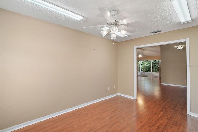 spare room featuring baseboards, a ceiling fan, and wood finished floors