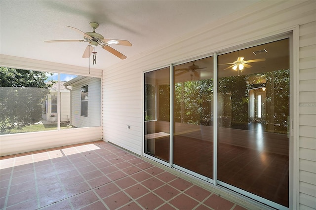 unfurnished sunroom with ceiling fan