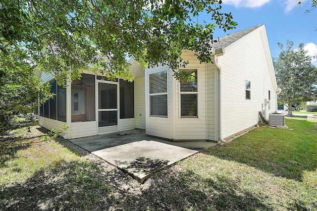 rear view of property featuring a patio, central air condition unit, a yard, and a sunroom