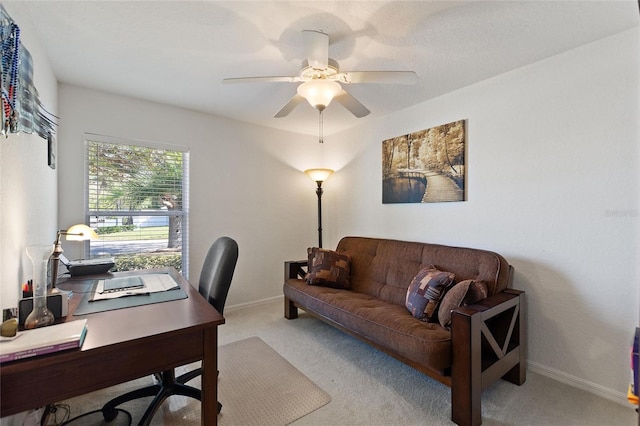 carpeted home office with baseboards and ceiling fan