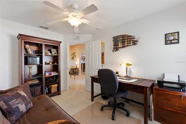 home office featuring ceiling fan, visible vents, and light carpet