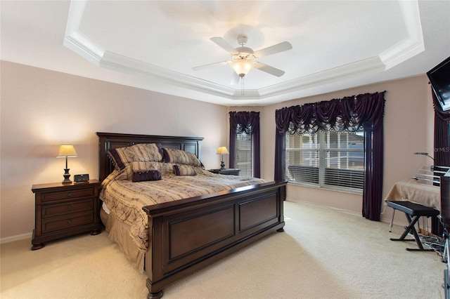 bedroom featuring a ceiling fan, a raised ceiling, light colored carpet, and baseboards