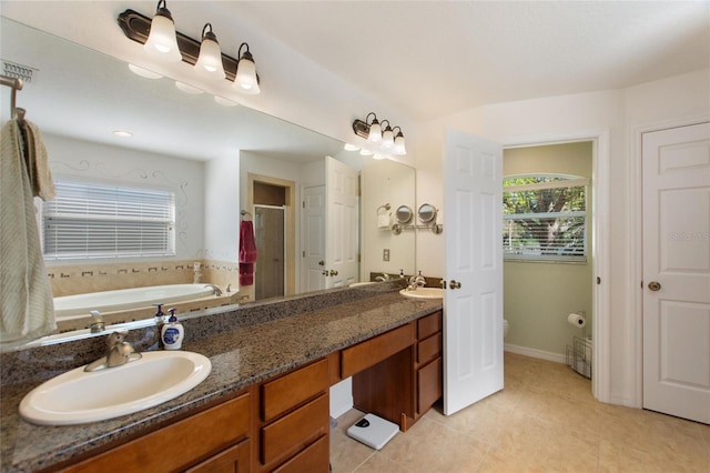 full bath with a sink, plenty of natural light, a bath, and double vanity