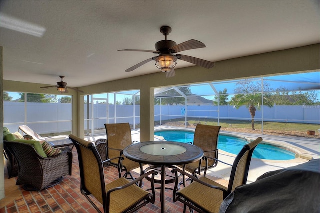 sunroom / solarium with a swimming pool and ceiling fan