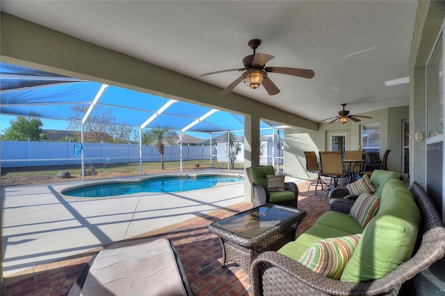 view of pool with an outdoor living space, ceiling fan, a lanai, a fenced backyard, and a patio