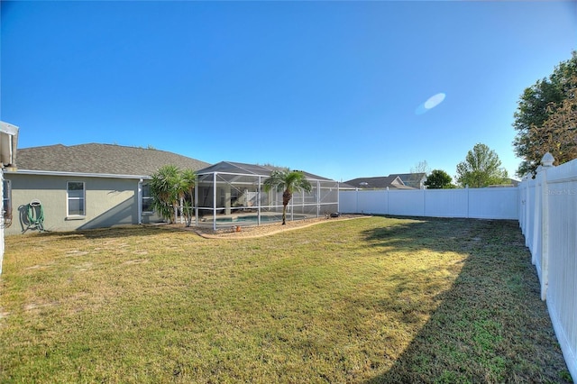 view of yard with glass enclosure, a fenced backyard, and a fenced in pool