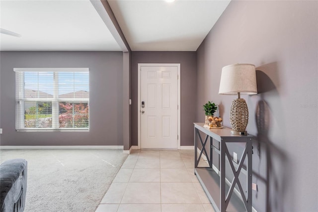 entrance foyer with light carpet, baseboards, and light tile patterned flooring