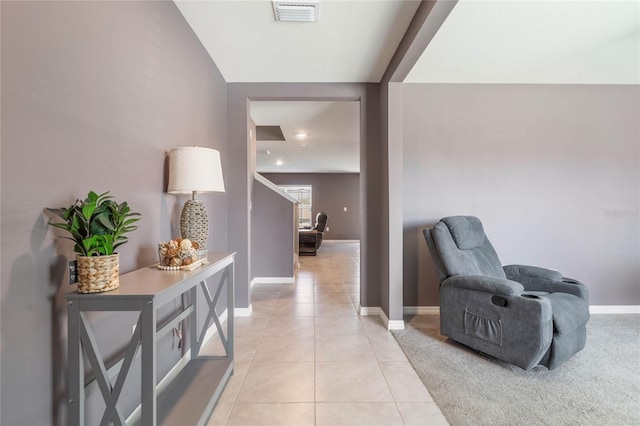 corridor featuring light tile patterned flooring, visible vents, and baseboards