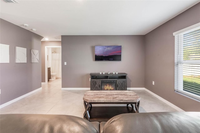 living area featuring light tile patterned flooring and baseboards