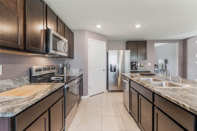 kitchen featuring a sink, recessed lighting, appliances with stainless steel finishes, light tile patterned flooring, and dark brown cabinets