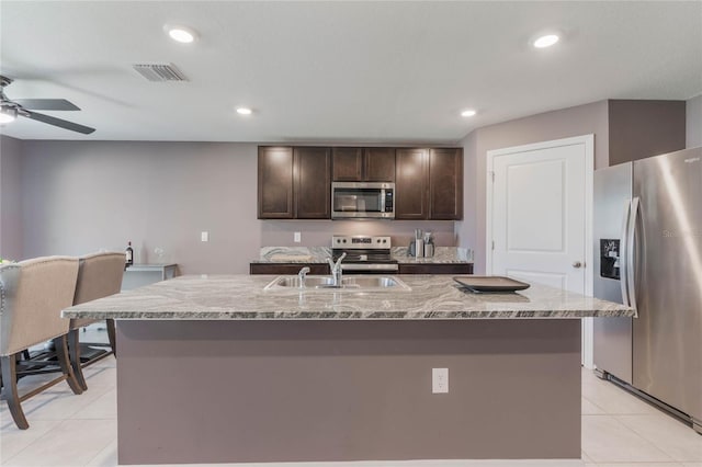 kitchen featuring visible vents, dark brown cabinetry, appliances with stainless steel finishes, a ceiling fan, and a sink