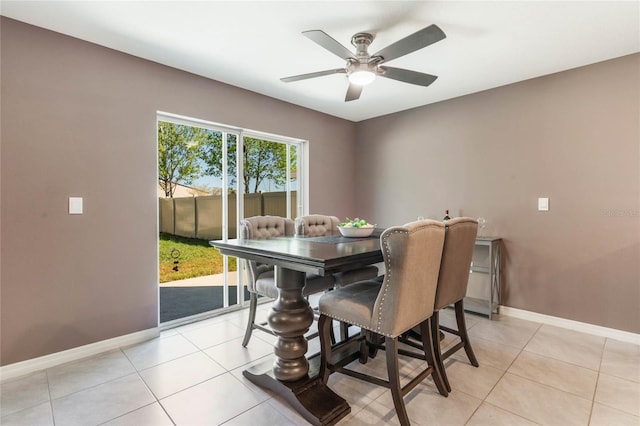 dining space featuring light tile patterned floors, a ceiling fan, and baseboards