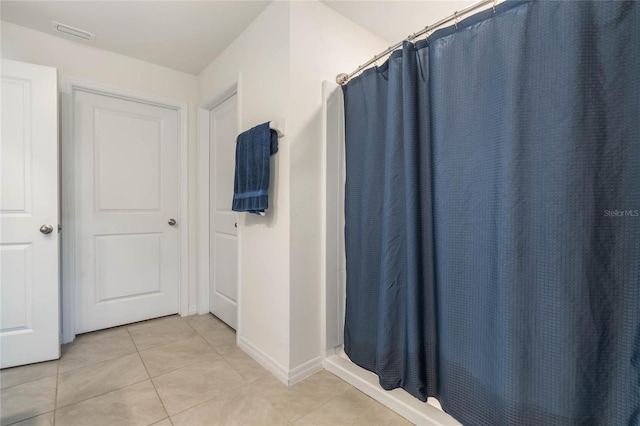bathroom featuring tile patterned flooring, curtained shower, baseboards, and visible vents