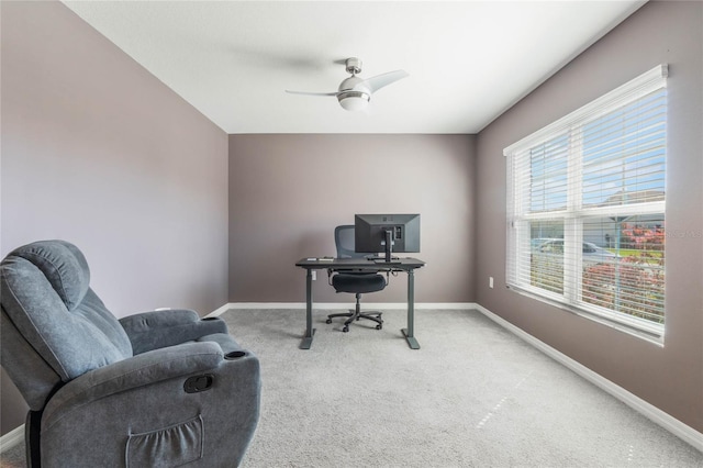 office area with a ceiling fan, baseboards, and light carpet