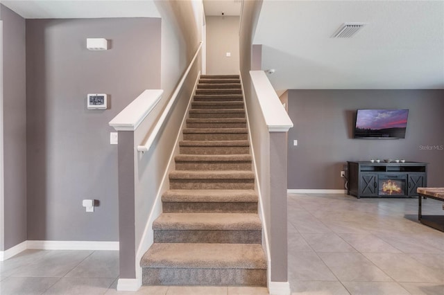 stairs with tile patterned flooring, baseboards, and visible vents