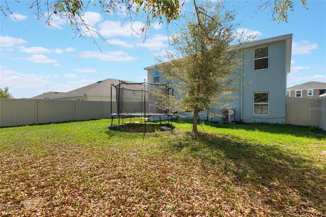 view of yard featuring a trampoline and a fenced backyard