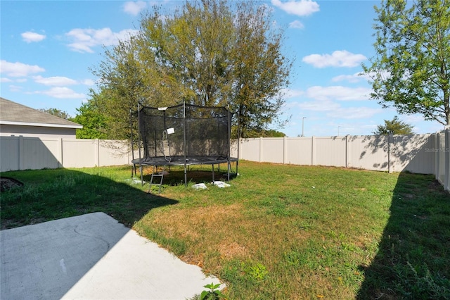 view of yard with a fenced backyard, a patio, and a trampoline