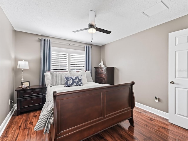 bedroom with dark wood-style floors, ceiling fan, a textured ceiling, and baseboards