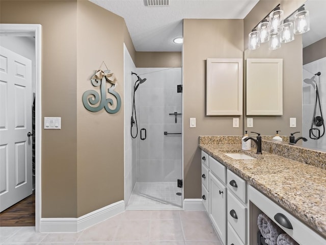 full bathroom featuring tile patterned floors, vanity, and a shower stall