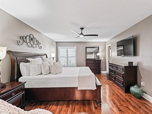 bedroom with ceiling fan, a textured ceiling, baseboards, and wood finished floors