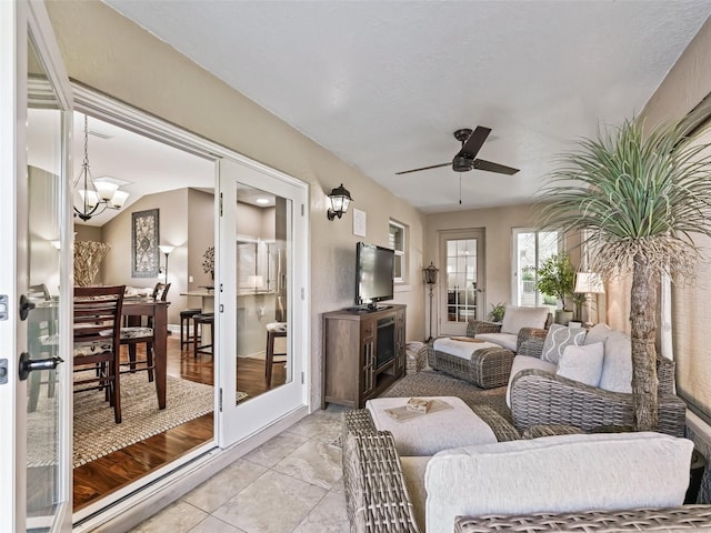 sunroom / solarium with ceiling fan with notable chandelier