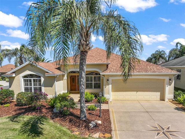 view of front of home with stucco siding, concrete driveway, an attached garage, and a shingled roof