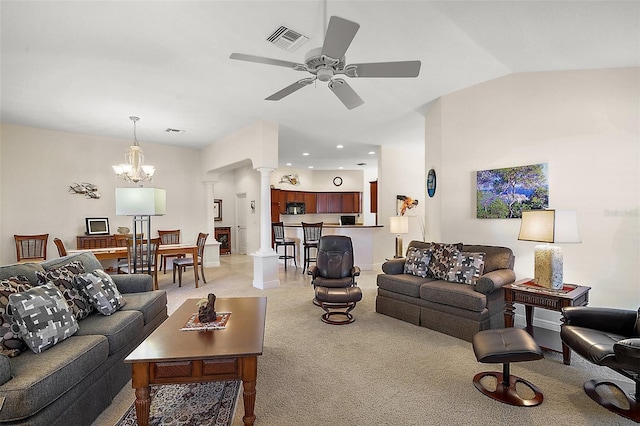 living room with a ceiling fan, visible vents, decorative columns, vaulted ceiling, and light colored carpet