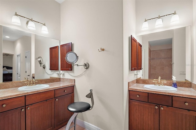 bathroom with a sink, baseboards, and two vanities