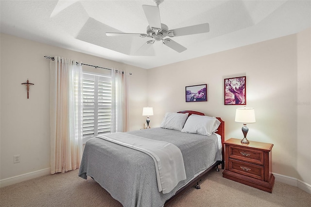 bedroom featuring light colored carpet, baseboards, and ceiling fan