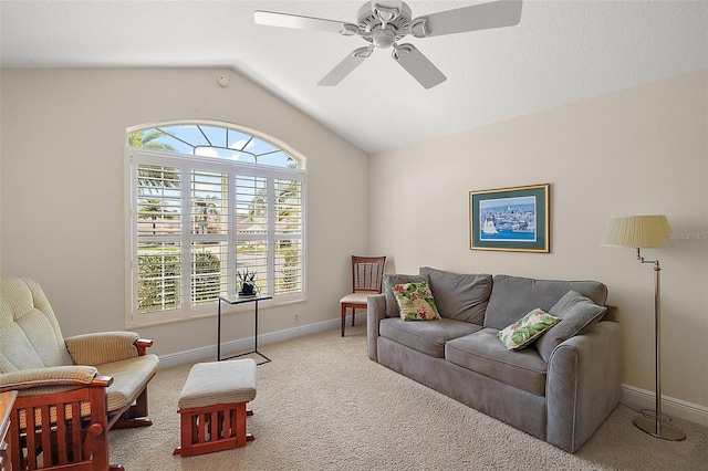 living area with baseboards, lofted ceiling, carpet floors, and a ceiling fan