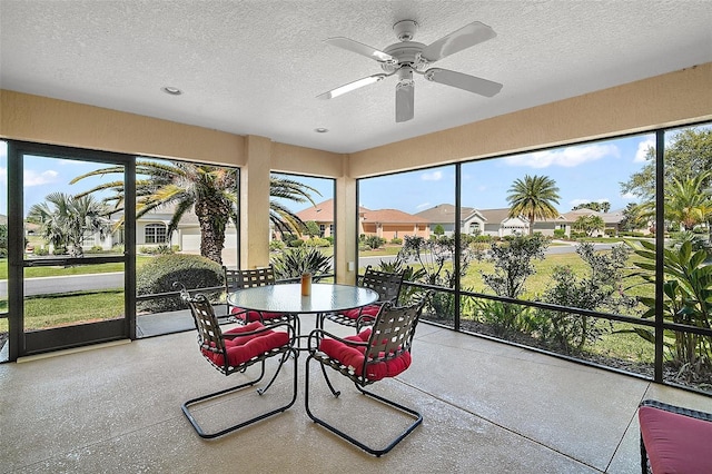 sunroom with a residential view and a ceiling fan