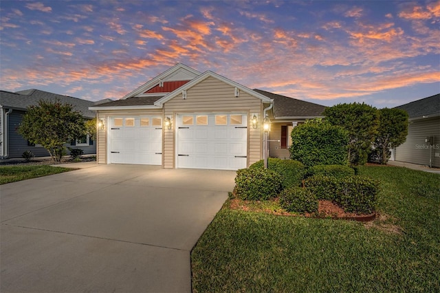 view of front of home with an attached garage, a yard, and driveway