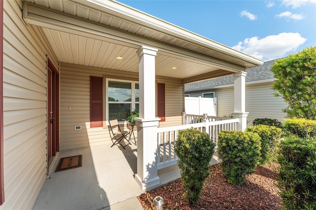 view of exterior entry featuring covered porch