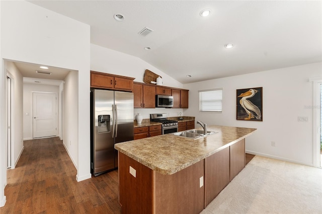 kitchen featuring visible vents, an island with sink, a sink, stainless steel appliances, and vaulted ceiling