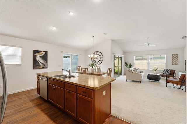 kitchen with a center island with sink, a sink, open floor plan, dishwasher, and vaulted ceiling