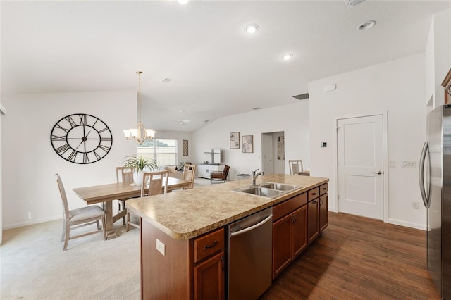 kitchen featuring lofted ceiling, an island with sink, a sink, light countertops, and appliances with stainless steel finishes