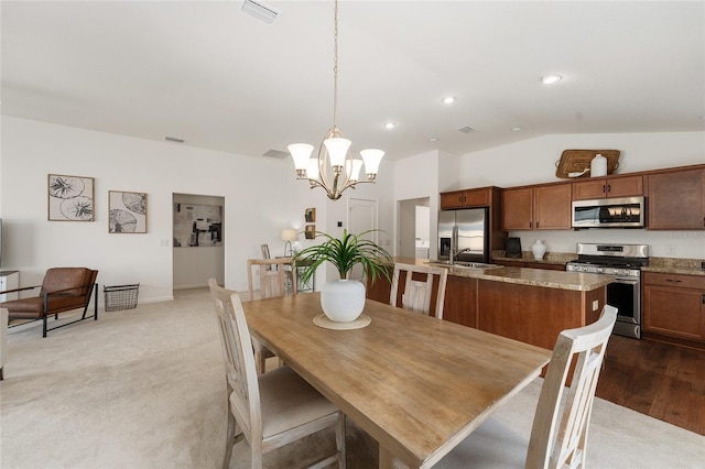 carpeted dining area featuring visible vents, lofted ceiling, recessed lighting, a notable chandelier, and a sink