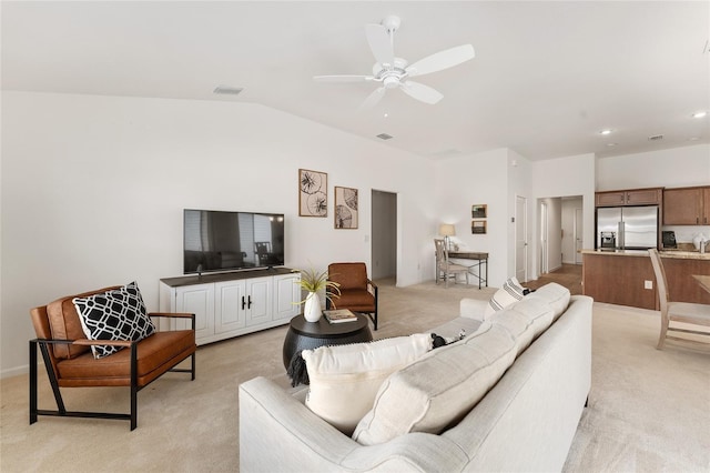 living room featuring lofted ceiling, a ceiling fan, visible vents, and light carpet