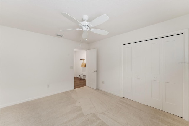 unfurnished bedroom with light colored carpet, visible vents, and a closet