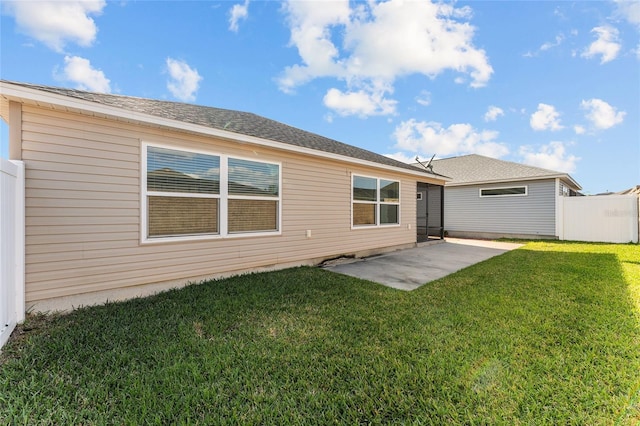 rear view of house featuring a lawn, a patio, and fence